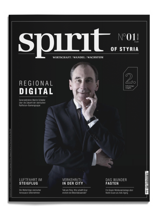 Das Titelbild eines Magazins zeigt einen Mann im Anzug, der mit der Hand am Kinn lächelt. Der Titel lautet "spirit of Styria" mit Schlagzeilen über digitales Wachstum und Wirtschaft.