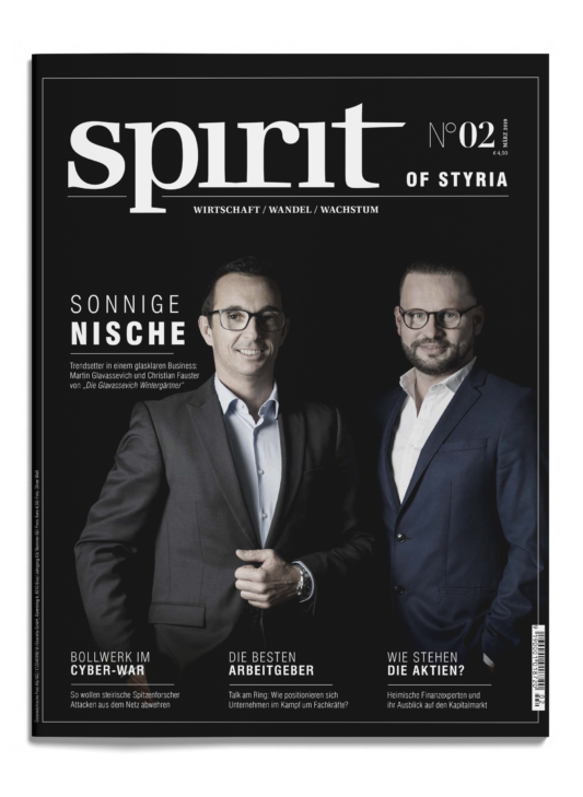 Zwei Männer in Geschäftskleidung stehen nebeneinander auf der Titelseite eines Magazins mit dem Titel "spirit of styria" und verschiedenen Artikelüberschriften in deutscher Sprache.