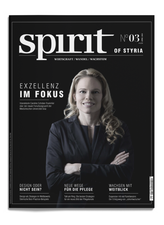 Eine Frau im Anzug mit verschränkten Armen lächelt selbstbewusst auf dem Cover des Magazins "spirit of styria", Ausgabe 3. Weißer Text hebt die Artikel hervor.