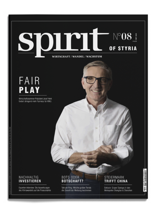 Ein lächelnder Mann mit Brille und weißem Hemd steht mit gefalteten Händen auf dem Cover des Magazins spirit of Styria", Ausgabe 08, mit verschiedenen Artikelüberschriften.