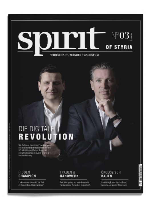 Zwei Männer in Anzügen stehen nebeneinander auf dem Cover des Magazins "spirit of styria", das Artikel über die digitale Revolution und nachhaltiges Bauen enthält.