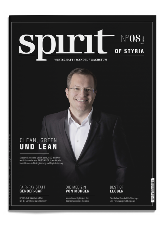 Ein Mann im Anzug und mit Brille lächelt auf dem Cover des Magazins "spirit of Styria", Ausgabe 08, mit Schlagzeilen in deutscher Sprache auf schwarzem Hintergrund.