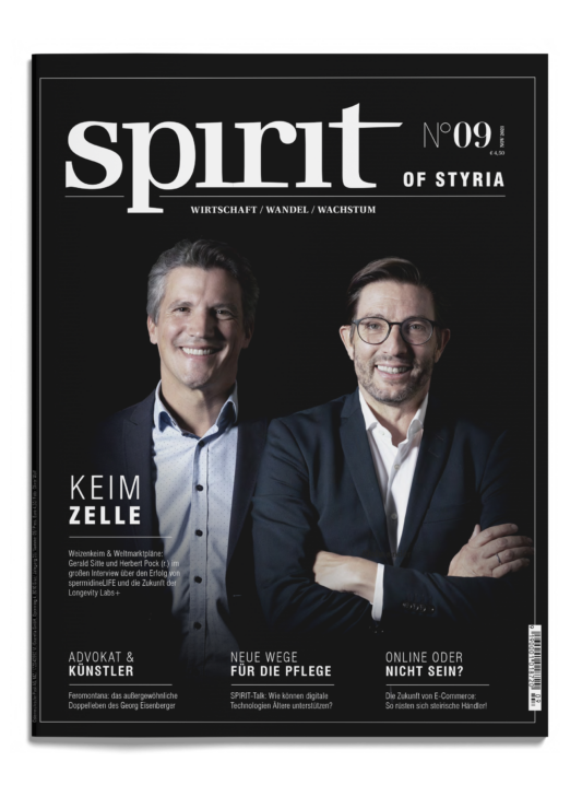 Zwei lächelnde Männer in Anzügen stehen nebeneinander auf dem Titelblatt des Magazins "spirit of styria", Ausgabe 09, mit deutschsprachigen Artikelüberschriften um sie herum.