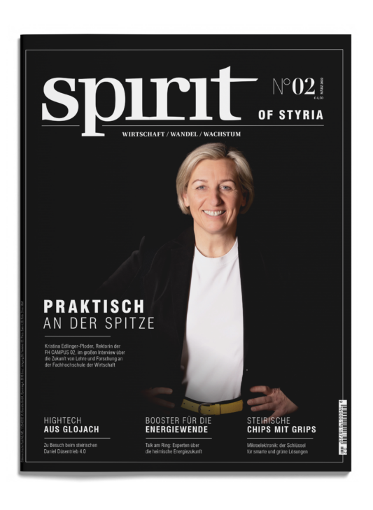 Eine Frau in schwarzem Blazer und weißem Hemd steht lächelnd auf dem Cover des Magazins spirit of Styria", Ausgabe 02, mit Schlagzeilen in deutscher Sprache.
