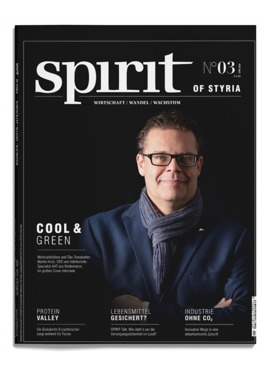 Ein Mann mit Brille und blauem Schal lächelt mit verschränkten Armen auf dem Cover des Magazins "spirit of styria", Ausgabe Nr. 03, mit deutschem Text.
