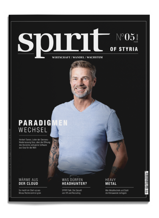 Ein lächelnder Mann in einem hellblauen T-Shirt steht vor einem grauen Hintergrund auf dem Cover des Magazins "spirit of Styria", Ausgabe 05.