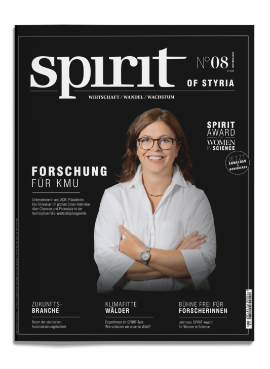 Eine lächelnde Frau mit Brille und weißer Bluse steht mit verschränkten Armen auf dem Titelblatt des Magazins "spirit", Ausgabe 08, mit Themen aus Wissenschaft und Wirtschaft.