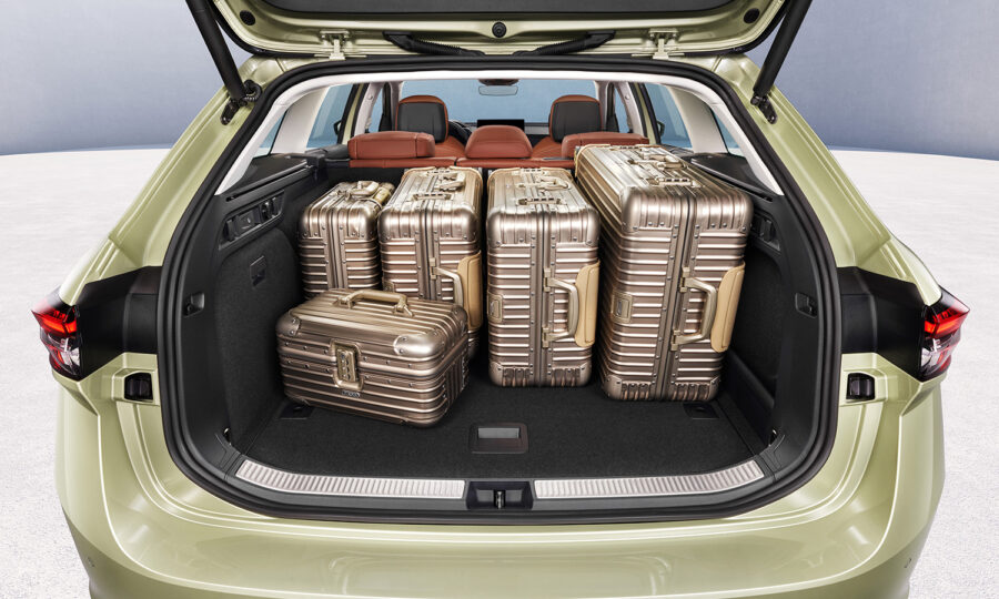 Der offene Kofferraum eines beigen Autos ist mit fünf metallisch-goldenen Koffern unterschiedlicher Größe gefüllt, was die geräumige Ladekapazität des Fahrzeugs zeigt. Im Hintergrund sind die braunen Innensitze des Fahrzeugs zu sehen.