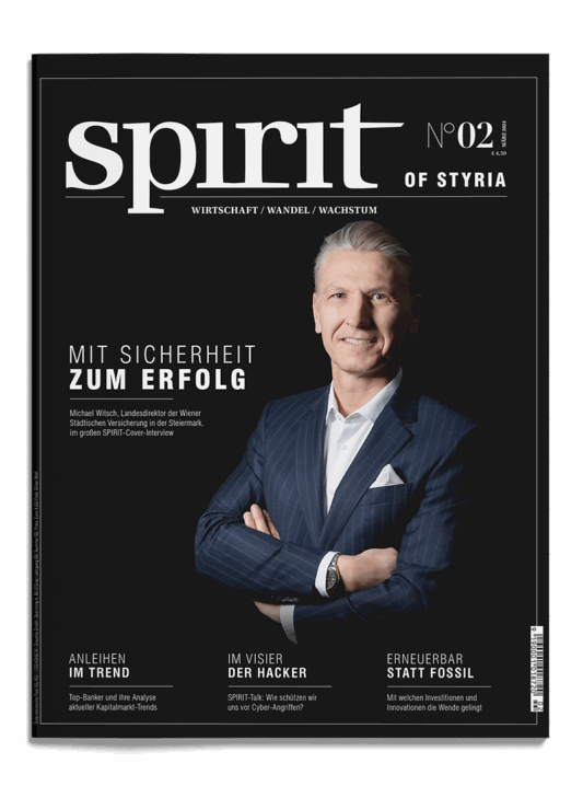 Das Titelbild einer Zeitschrift mit dem Titel "spirit of STYRIA" zeigt einen lächelnden Mann mittleren Alters in einem Anzug mit verschränkten Armen. Die Schlagzeilen behandeln Themen wie Sicherheit, Finanztrends, Hacking und erneuerbare Energien.