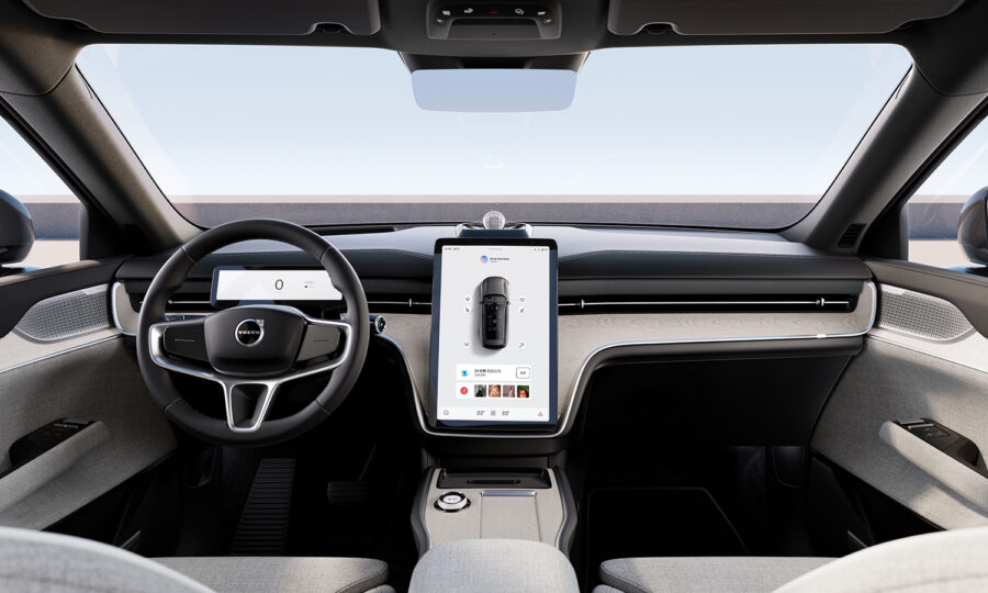 Ansicht eines modernen Autoinnenraums mit digitalem Armaturenbrett, einem großen zentralen Touchscreen-Display, minimalistischem Design, hellen Polstern und einem eleganten Lenkrad, wobei durch die Windschutzscheibe ein klarer Himmel zu sehen ist.