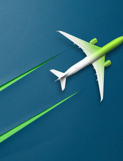 Ein grünes und weißes Flugzeug fliegt über einen blauen Hintergrund und hinterlässt zwei grüne Streifen, die Geschwindigkeit oder umweltfreundliches Fliegen symbolisieren.