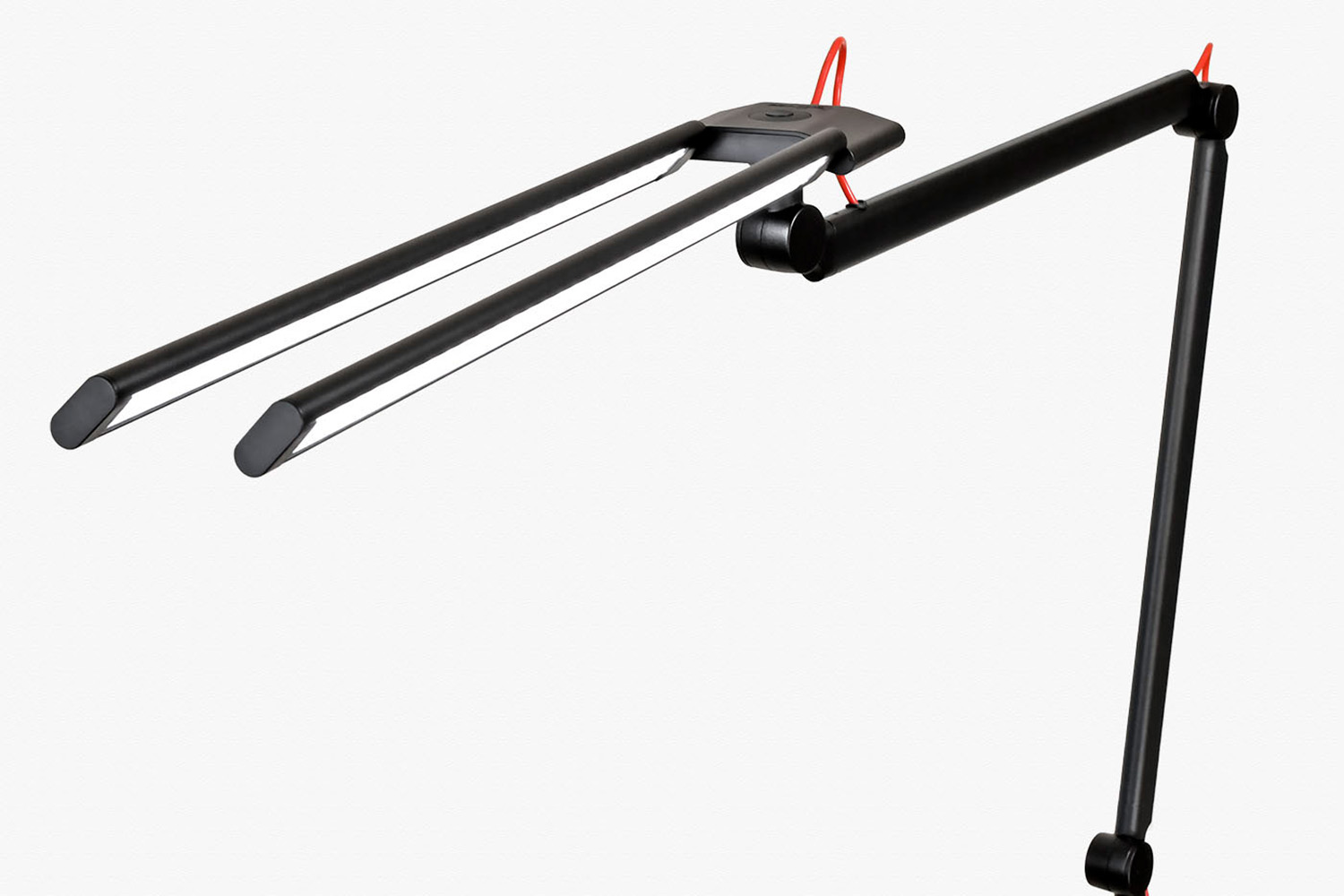 Eine moderne, verstellbare Schreibtischlampe mit zwei langen, schlanken schwarzen Armen und roten Stromkabeln, die in einem Winkel angeordnet sind. Die Lampe hat ein minimalistisches, zeitgenössisches Design.