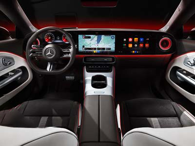 Innenansicht eines modernen Mercedes-Benz Fahrzeugs mit digitalem Armaturenbrett, beleuchteter Ambientebeleuchtung, einem großen zentralen Touchscreen für die Navigation und eleganten schwarz-weißen Sitzen.