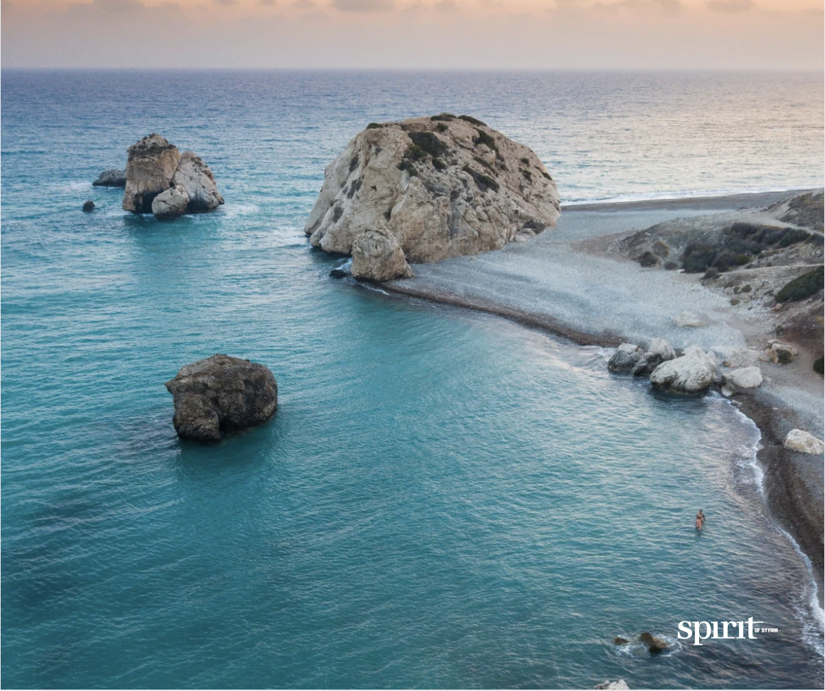 Luftaufnahme einer felsigen Küste mit türkisfarbenem Wasser, großen Felsformationen im Meer und einem schmalen Strand bei Sonnenuntergang. Das Wort "Geist" erscheint in der unteren rechten Ecke.
