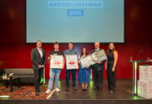 Sechs Personen stehen beim "Masterclass Finale 2025" auf der Bühne. Drei in der Mitte halten große Urkunden und eine Schlüsselrequisite, drei weitere von der langen Tafel Graz stehen daneben und lächeln für ein Gruppenfoto.