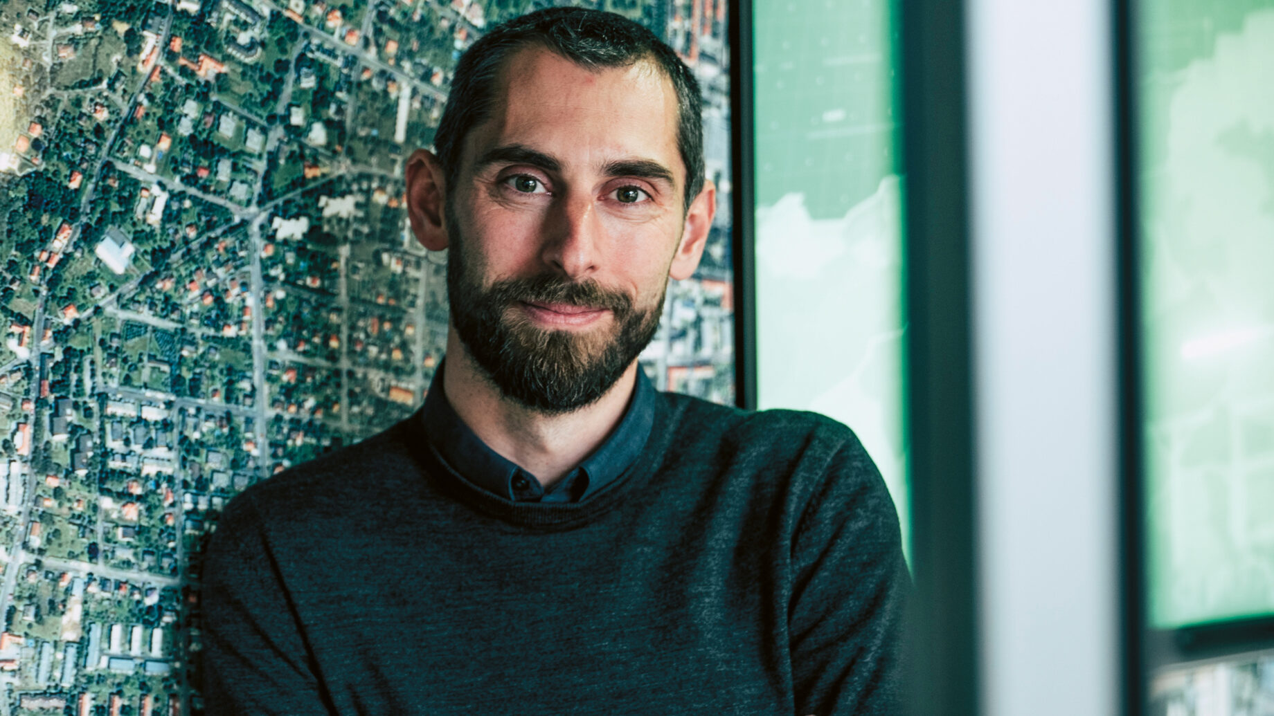 Ein Mann steht vor einer Landkarte.