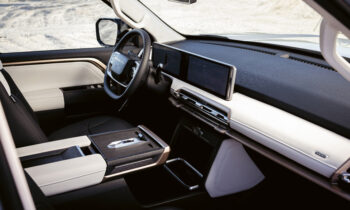 Modernes Interieur mit digitalem Armaturenbrett, Touchscreen-Display, schwarzen und weißen Ledersitzen und einer eleganten Mittelkonsole.