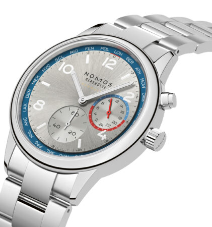 Eine silberne NOMOS Glashütte-Armbanduhr mit Metallband, blauen Akzenten, zwei Hilfszifferblättern und einem grauen, strukturierten Zifferblatt, schräg dargestellt.