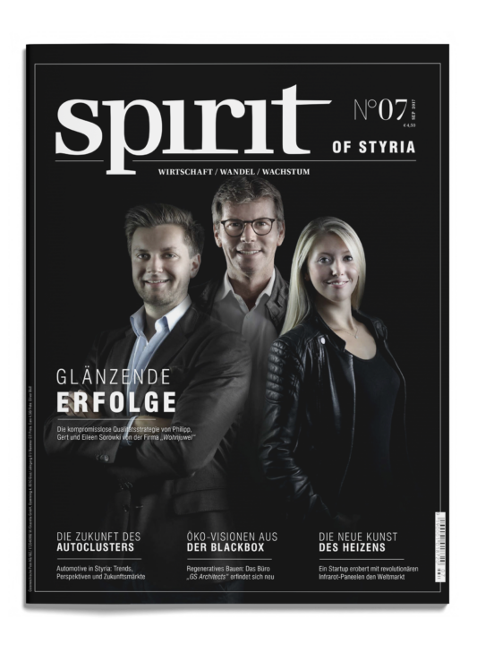 Drei Personen, zwei Männer und eine Frau, stehen lächelnd auf der Titelseite eines Magazins mit dem Titel "spirit of styria", das Schlagzeilen aus der Wirtschaft enthält.