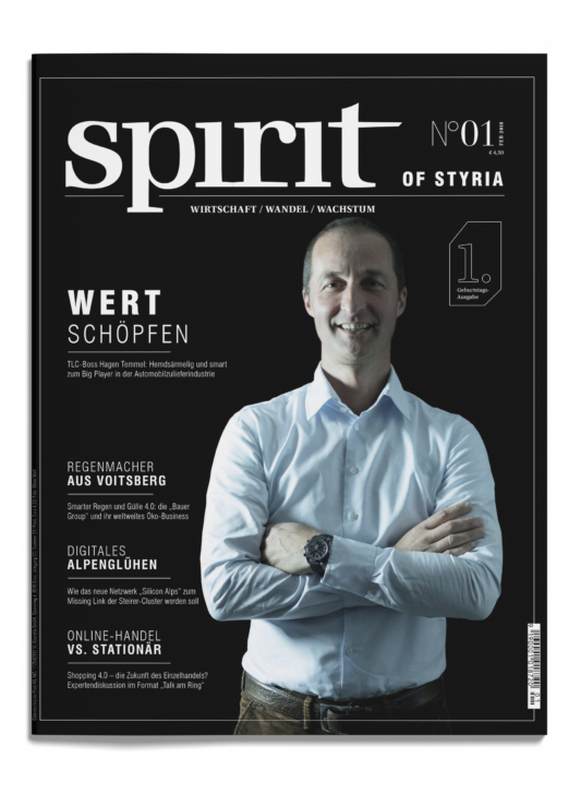 Ein Mann im weißen Hemd steht lächelnd und mit verschränkten Armen auf dem Cover des Magazins "Spirit of Styria", das Schlagzeilen aus der Wirtschaft zeigt.