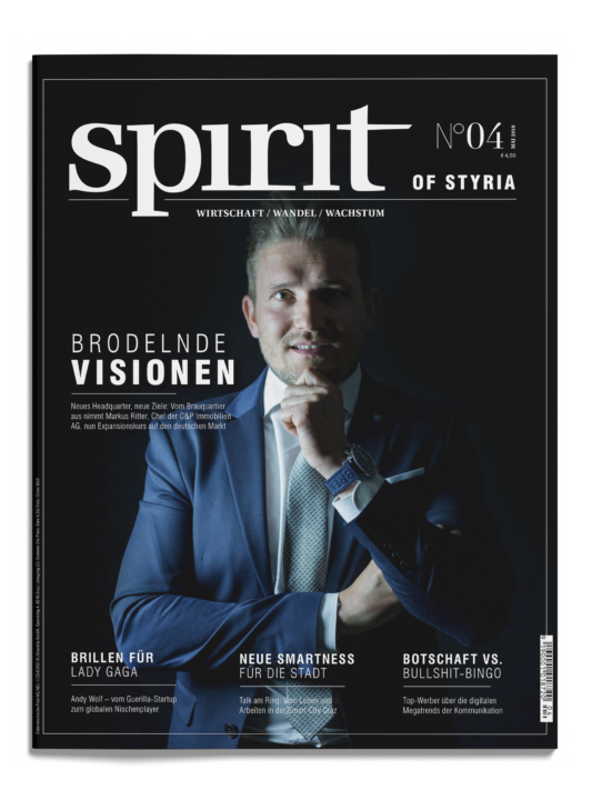 Ein Mann im blauen Anzug mit weißem Hemd und Krawatte posiert nachdenklich auf dem Cover des Magazins "Spirit of Styria", Ausgabe 04, mit Artikelüberschriften in deutscher Sprache.
