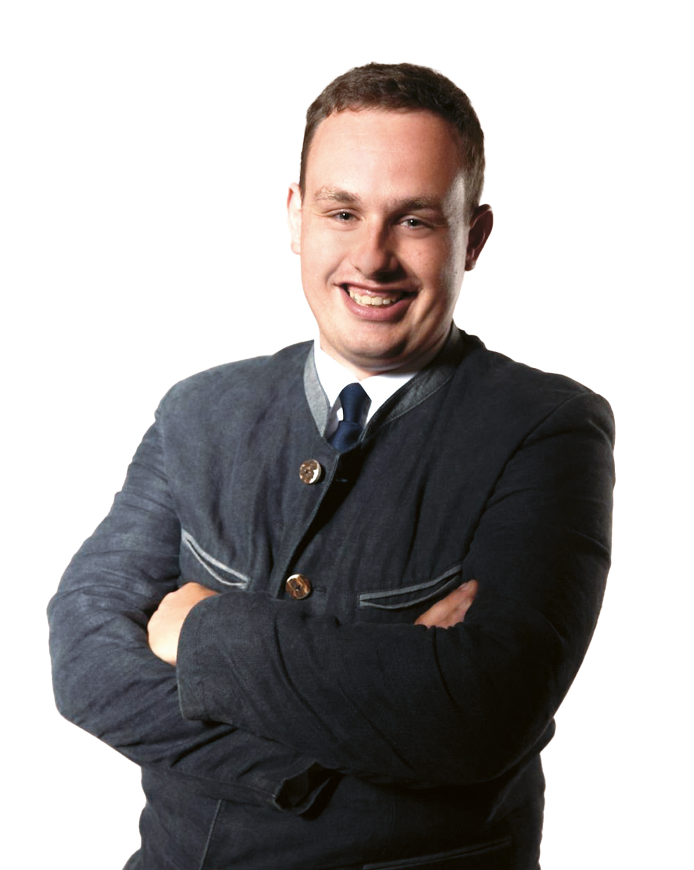 Lächelnder Mann in einer dunklen Jacke mit verschränkten Armen, der vor einem schlichten weißen Hintergrund steht.