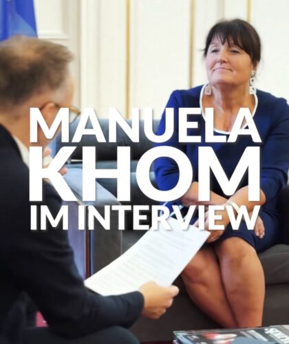 Zwei Personen sitzen sich in einem Interview gegenüber und sprechen.