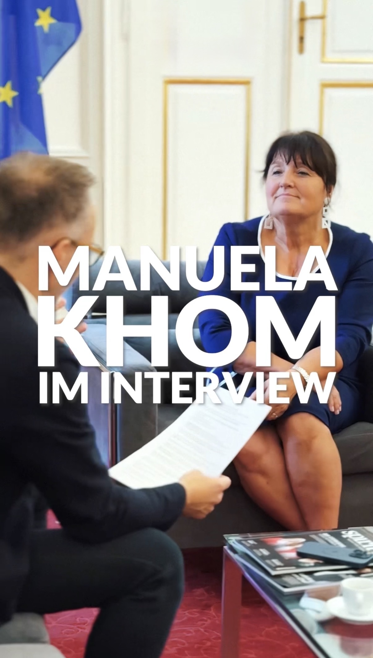 Zwei Personen sitzen sich in einem Interview gegenüber und sprechen.