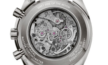 Rückansicht einer Omega-Armbanduhr mit freiliegenden, komplizierten mechanischen Zahnrädern, beschriftet mit "Grey Side of the Moon" an einem schwarzen Lederarmband.