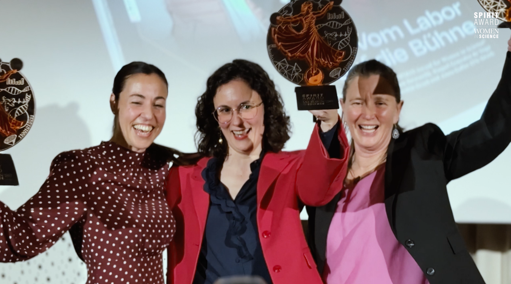 Drei Frauen feiern mit ihren Trophäen bei der Verleihung des Preises für Frauen in der Wissenschaft.