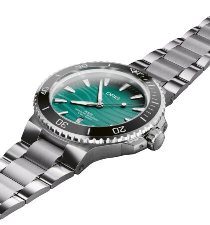 Eine silberne Metallarmbanduhr mit grünem Zifferblatt, weißen Markierungen und einer drehbaren schwarzen Lünette auf weißem Hintergrund.