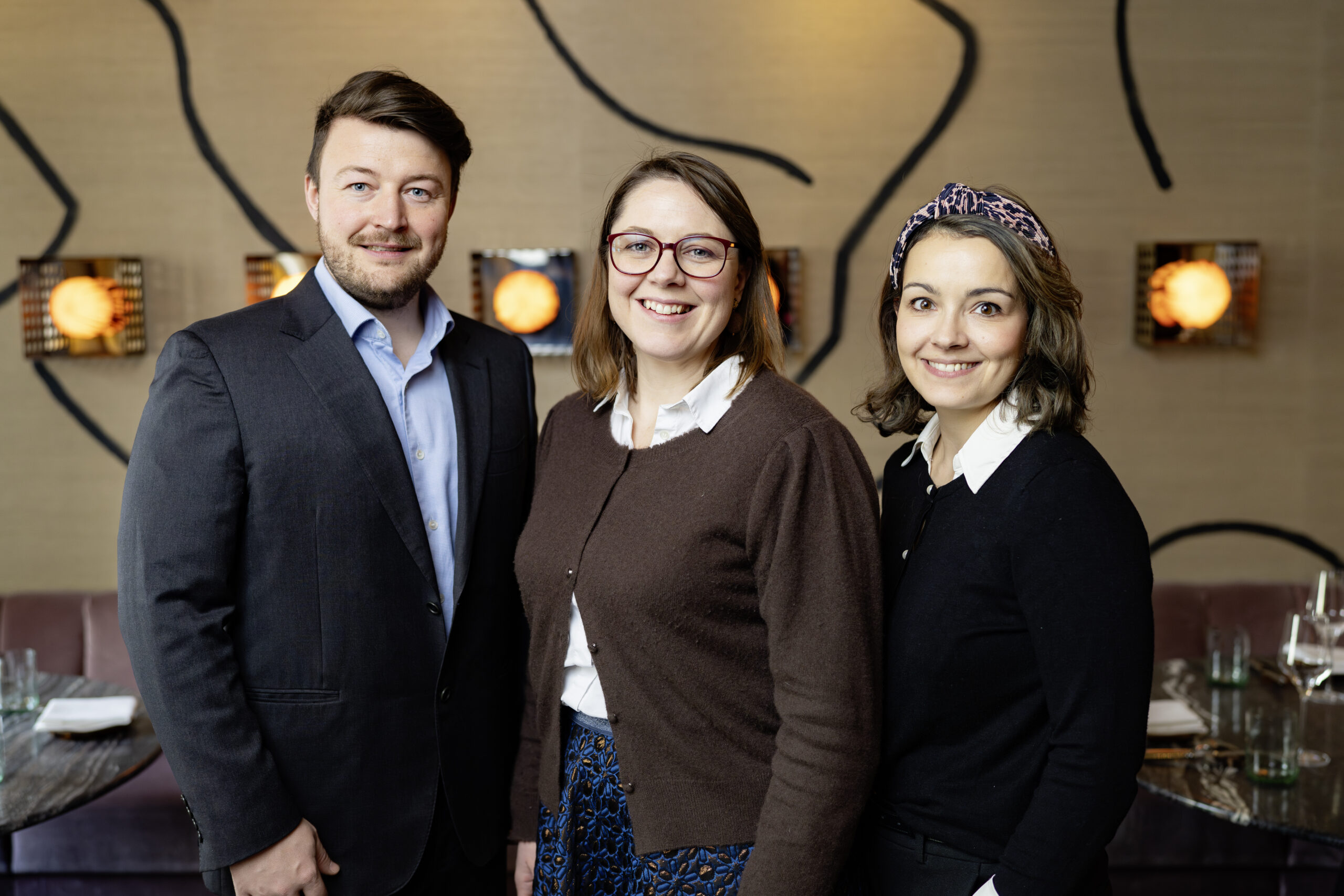 Drei Personen lächeln in einem Restaurant in die Kamera, um die Meisterbriefverleihung 2026 im Grazer Congress Rekord für die Steiermark zu feiern.