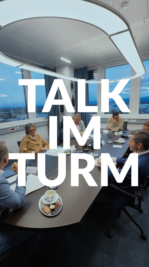 Sechs Personen in Business-Kleidung treffen sich in einem modernen Büro. Der große Text lautet: "TALK IM TURM".