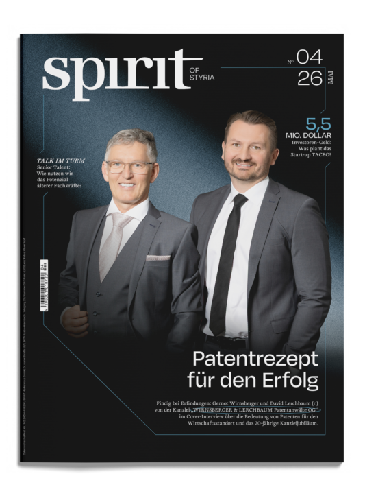 Zwei Männer in Anzügen lächeln auf dem Cover des Magazins "Spirit of Styria", Ausgabe 04/26, mit deutschen Textüberschriften über Investitionen und Erfolg.