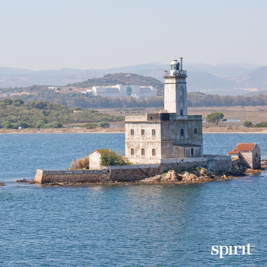 Ein verwitterter Leuchtturm steht auf einer felsigen Insel und blickt auf das ruhige blaue Wasser - eine Szene, die so unerschütterlich ist wie die Vision der GRAWE Bilanz 2025.