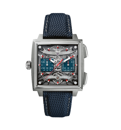 Eine quadratische TAG Heuer Monaco-Uhr mit blauem strukturiertem Armband, blauem Zifferblatt, sichtbaren mechanischen Details und silbernen Akzenten.