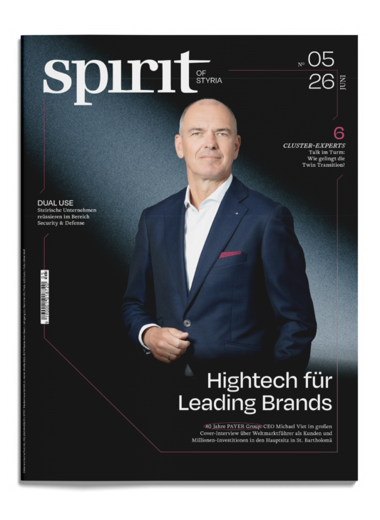 Ein Mann im Anzug steht selbstbewusst auf dem Cover der Zeitschrift „Spirit of Styria“, Ausgabe 5/26, mit deutschen Schlagzeilen zu den Themen Technologie und Wirtschaft.