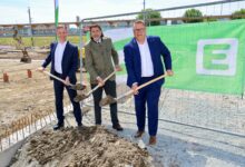 Drei Männer in Anzügen machen den ersten Spatenstich für den Glasfaserausbau Steiermark. Sie stehen vor einem grünen "Energie Steiermark"-Banner auf der Baustelle.