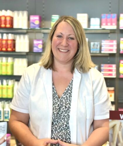 Christine Gradwohl aus Graz lächelt im weißen Kittel hinter dem Tresen - Apotheken-Stars gesucht!