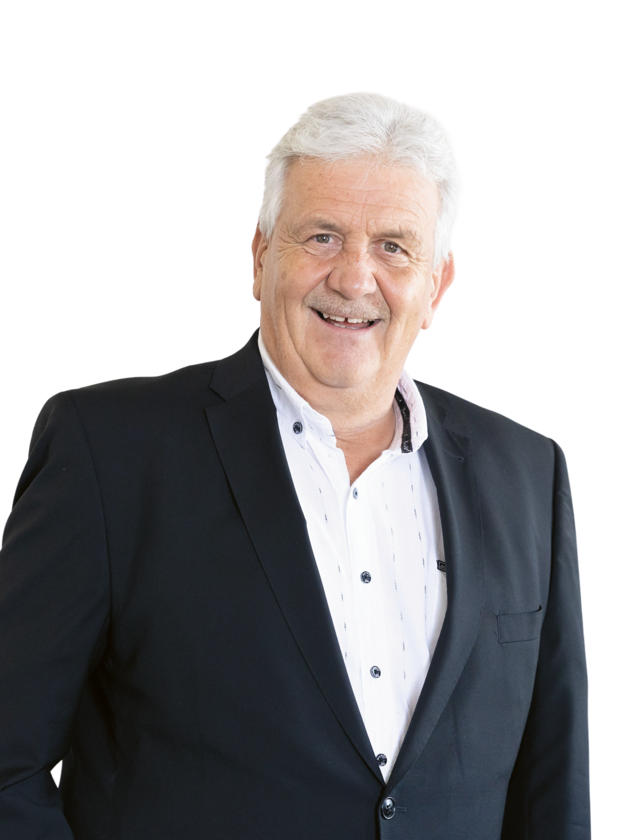 Ein älterer Mann mit grauen Haaren, der ein schwarzes Sakko und ein weißes Hemd trägt und vor einem schlichten weißen Hintergrund lächelt.