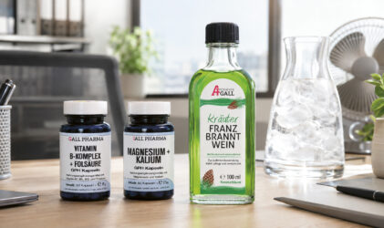 Auf einem Schreibtisch stehen zwei Flaschen mit Nahrungsergänzungsmitteln und eine grüne Franzbranntwein-Flasche, im Hintergrund sind ein Krug mit Eiswasser, ein Glas und Büromaterial zu sehen.