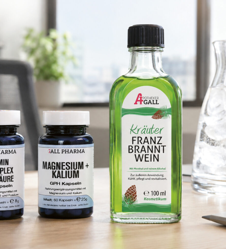 Auf einem Schreibtisch stehen zwei Flaschen mit Nahrungsergänzungsmitteln und eine grüne Franzbranntwein-Flasche, im Hintergrund sind ein Krug mit Eiswasser, ein Glas und Büromaterial zu sehen.