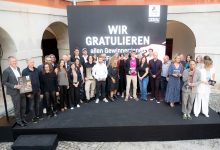 Eine Gruppe posiert auf der Bühne der EBSCON 2026 vor einem Schild mit der Aufschrift „WIR GRATULIEREN“ während einer Preisverleihung.