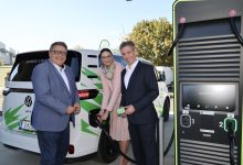 Drei Personen stehen neben einem weißen Volkswagen-Elektrotransporter im neuen Logistikzentrum von Energie Steiermark in Frohnleiten, wobei eine Frau gerade das Kabel einsteckt.