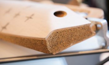 Eine Nahaufnahme eines Holzgegenstands mit strukturierter Kork-Hirnschnittfläche und einem runden Loch.