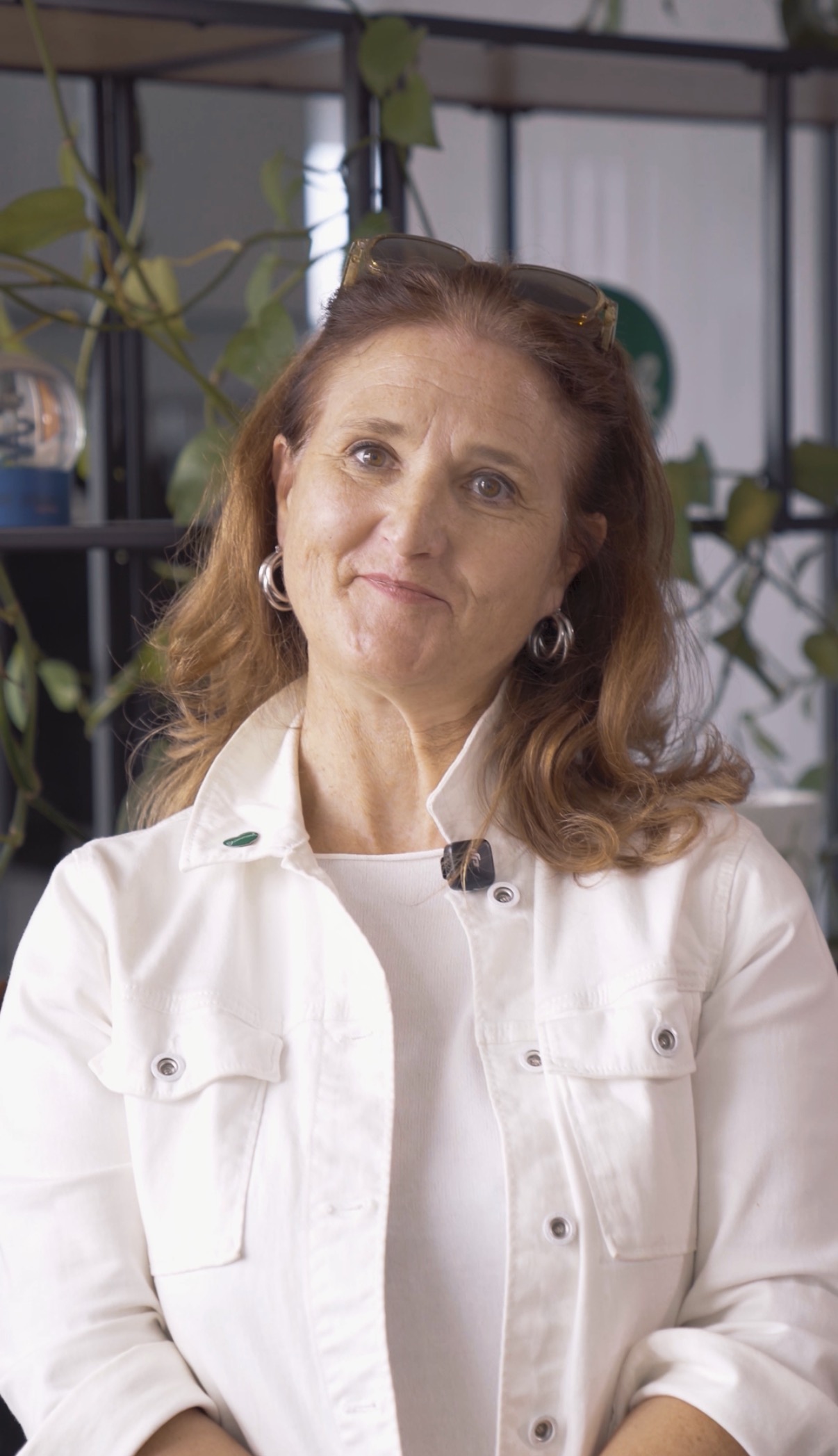 Susanne Haubenhofer mit rotbraunen Haaren und einer weißen Jacke lächelt in die Kamera.