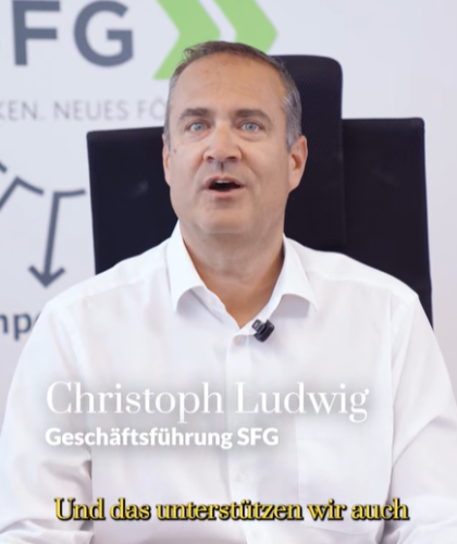 Christoph Ludwig, Geschäftsführer der SFG, spricht in einer Büroumgebung, unterlegt mit Text.