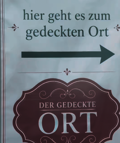Schild mit einem nach rechts zeigenden Pfeil und der Aufschrift „Hier geht es zum gedeckten Ort“ sowie „DER GEDECKTE ORT“ – ein Millionendeal als Wachstumsturbo.